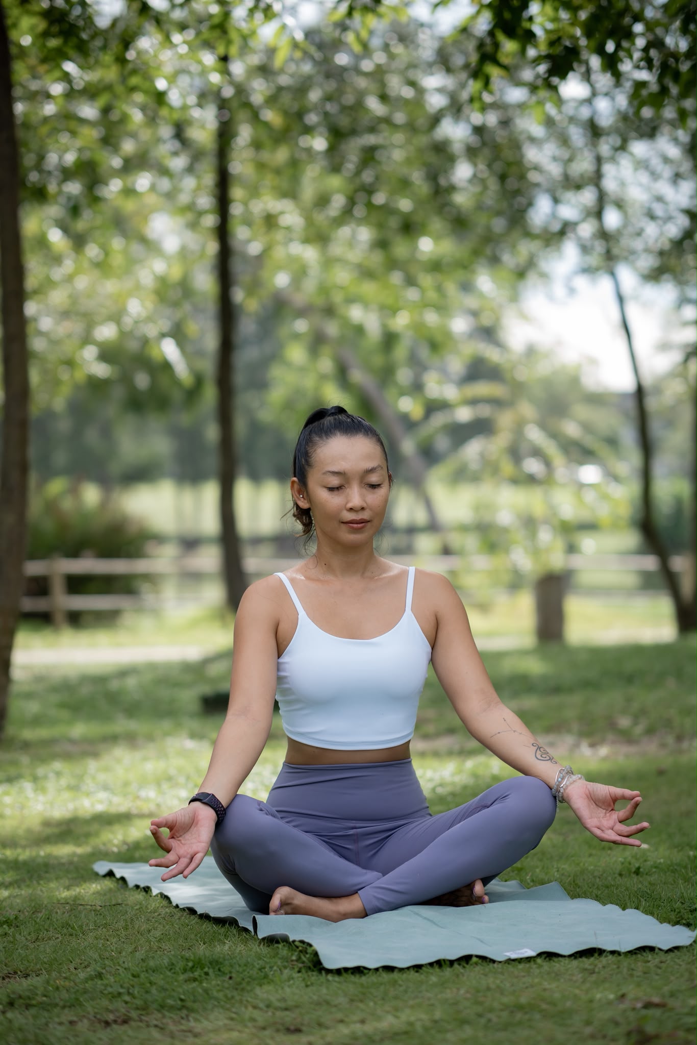 Am seated in meditation outdoors on a yoga mat
